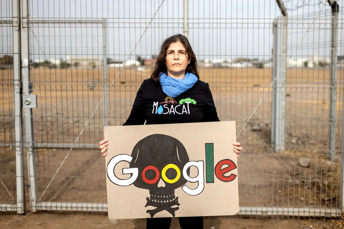 Tania Rodríguez, del collettivo Mosacat, con un cartello di protesta davanti al terreno di Google a Cerrillos.
